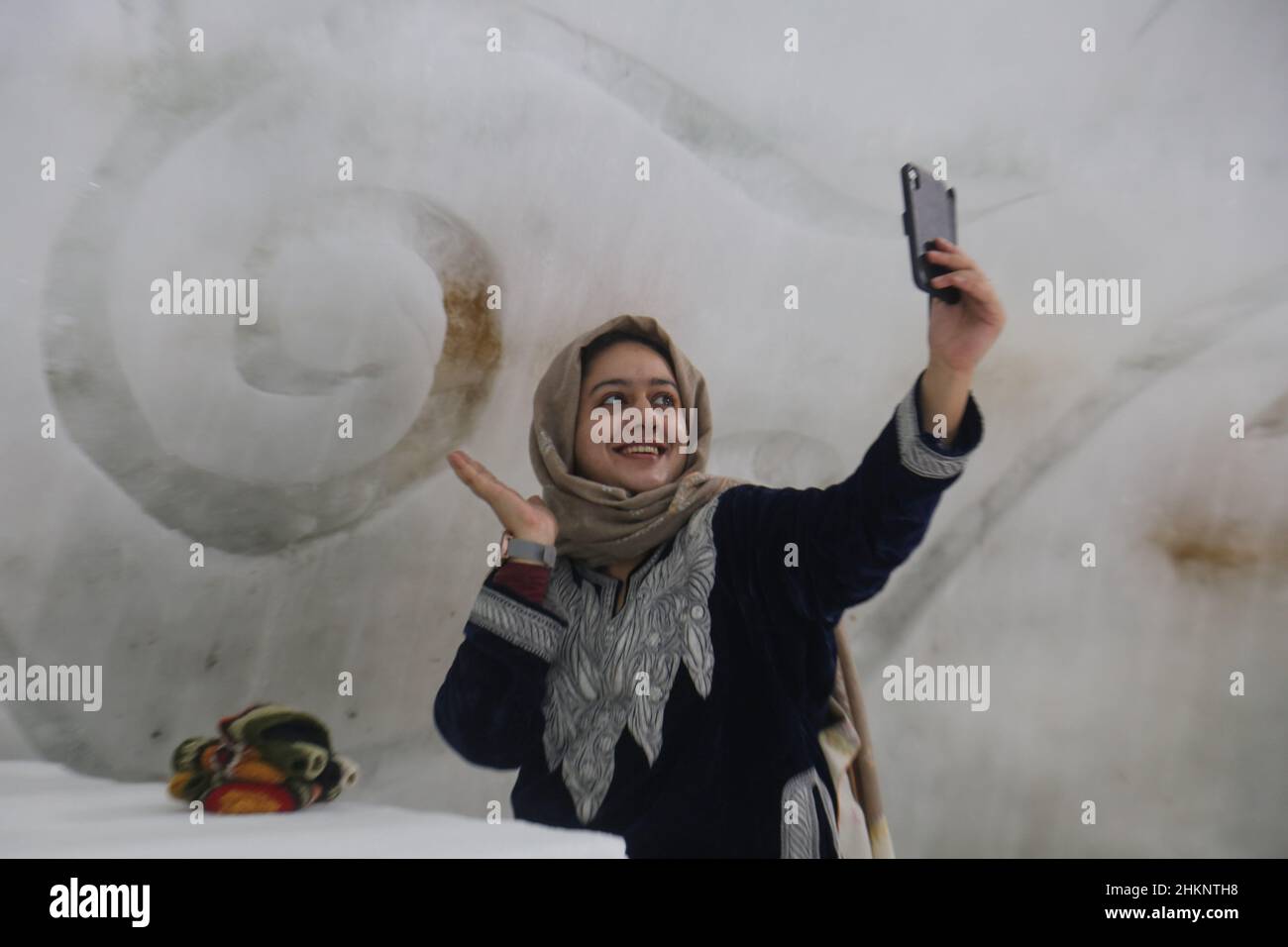 Srinagar, India. 05th Feb 2022. Una ragazza turistica prende selfie all'interno del più grande Igloo Cafe in Asia fatto di neve a Gulmarg. L'Igloo Cafe e' alto circa 37,5 piedi e rotondo 45 piedi e puo' ospitare quindici tavoli e circa 60 ospiti. L'Igloo Cafe offre tavoli fatti di ghiaccio e neve, con piatti caldi serviti ai visitatori. (Foto di Sajad Hameed/Pacific Press) Credit: Pacific Press Media Production Corp./Alamy Live News Foto Stock