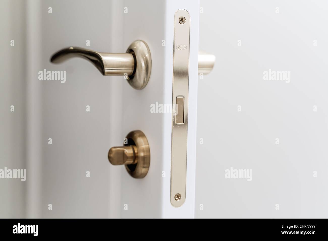 Elegante maniglia e serratura in bronzo su una nuova porta interna bianca  Foto stock - Alamy