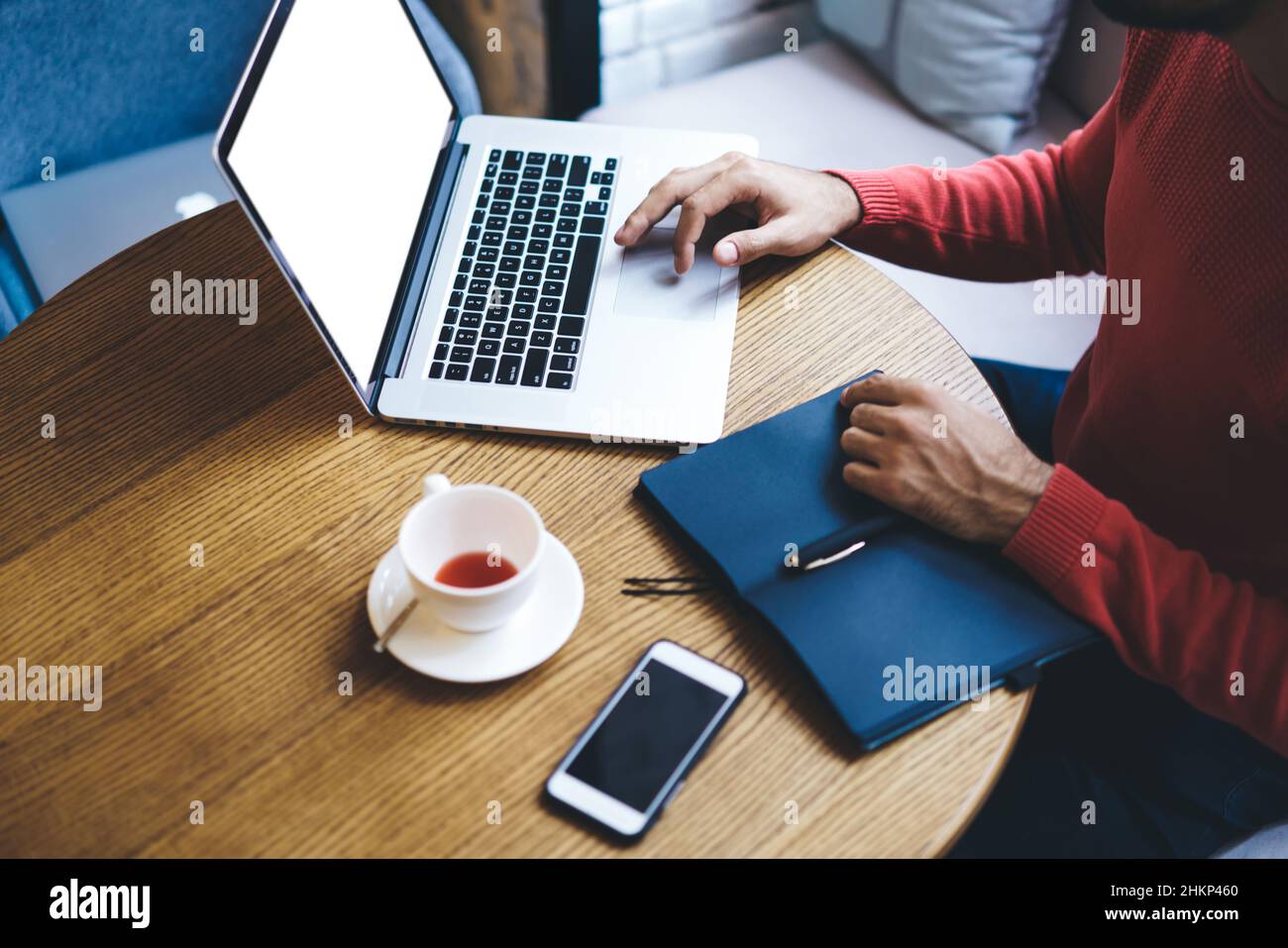 Ritagliare l'imprenditore maschile utilizzando un computer portatile in un caffè Foto Stock