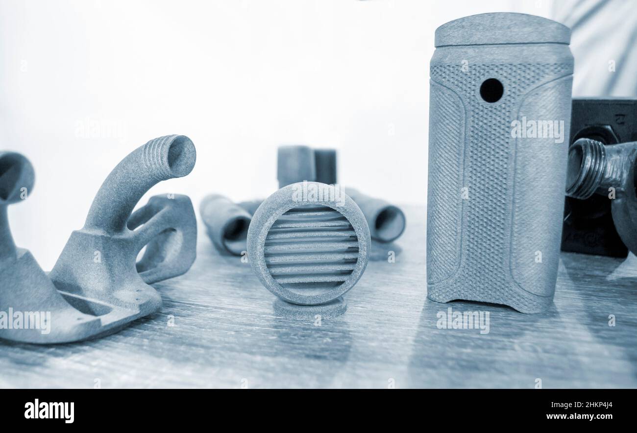 Diversi oggetti grigi stampati su stampante industriale a polvere 3D tridimensionale Foto Stock