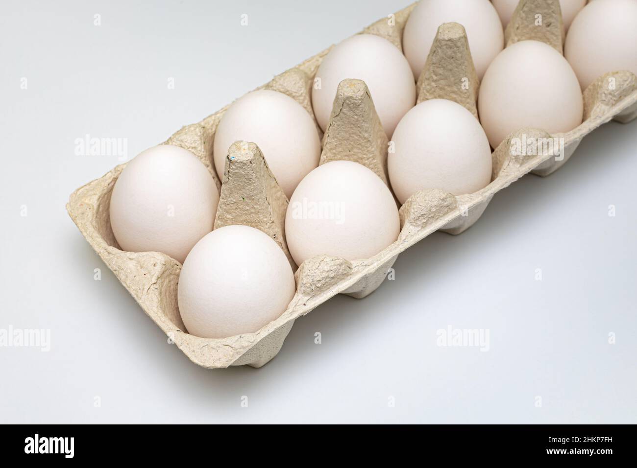 scatola di cartone con uova bianche fotografate con fuoco selettivo Foto Stock