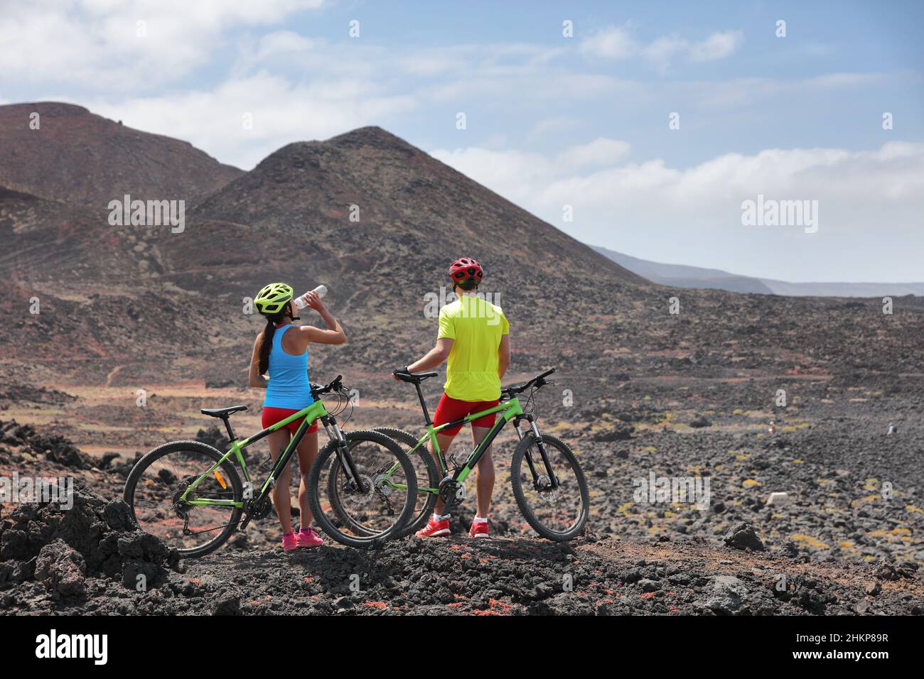 Avventura in bicicletta mountain bike MTB ciclisti ciclisti ciclisti su un paesaggio vulcanico di lava estrema. Due ciclisti in tour guidato di gruppo in vacanza estiva Foto Stock