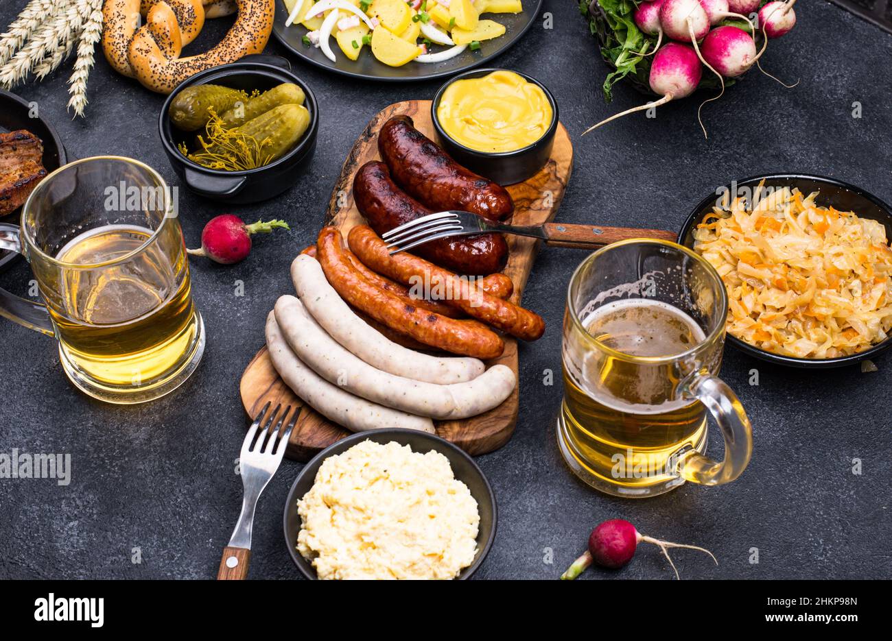 Piatti Oktoberfest con birra, pretzel e salsiccia Foto Stock