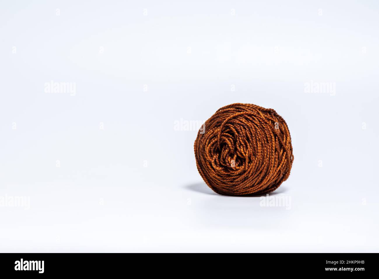 Biglia di filo marrone e di medie dimensioni su sfondo bianco Foto Stock