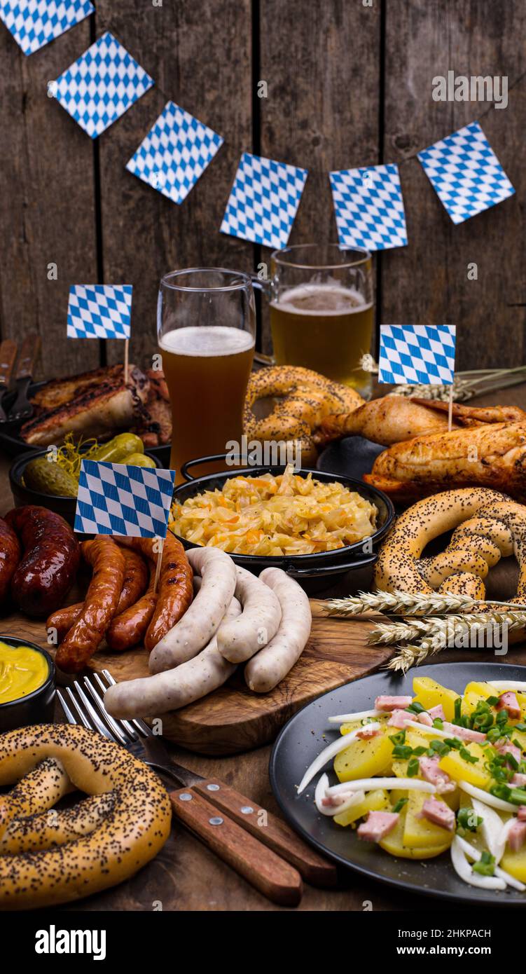 Piatti Oktoberfest con birra, pretzel e salsiccia Foto Stock