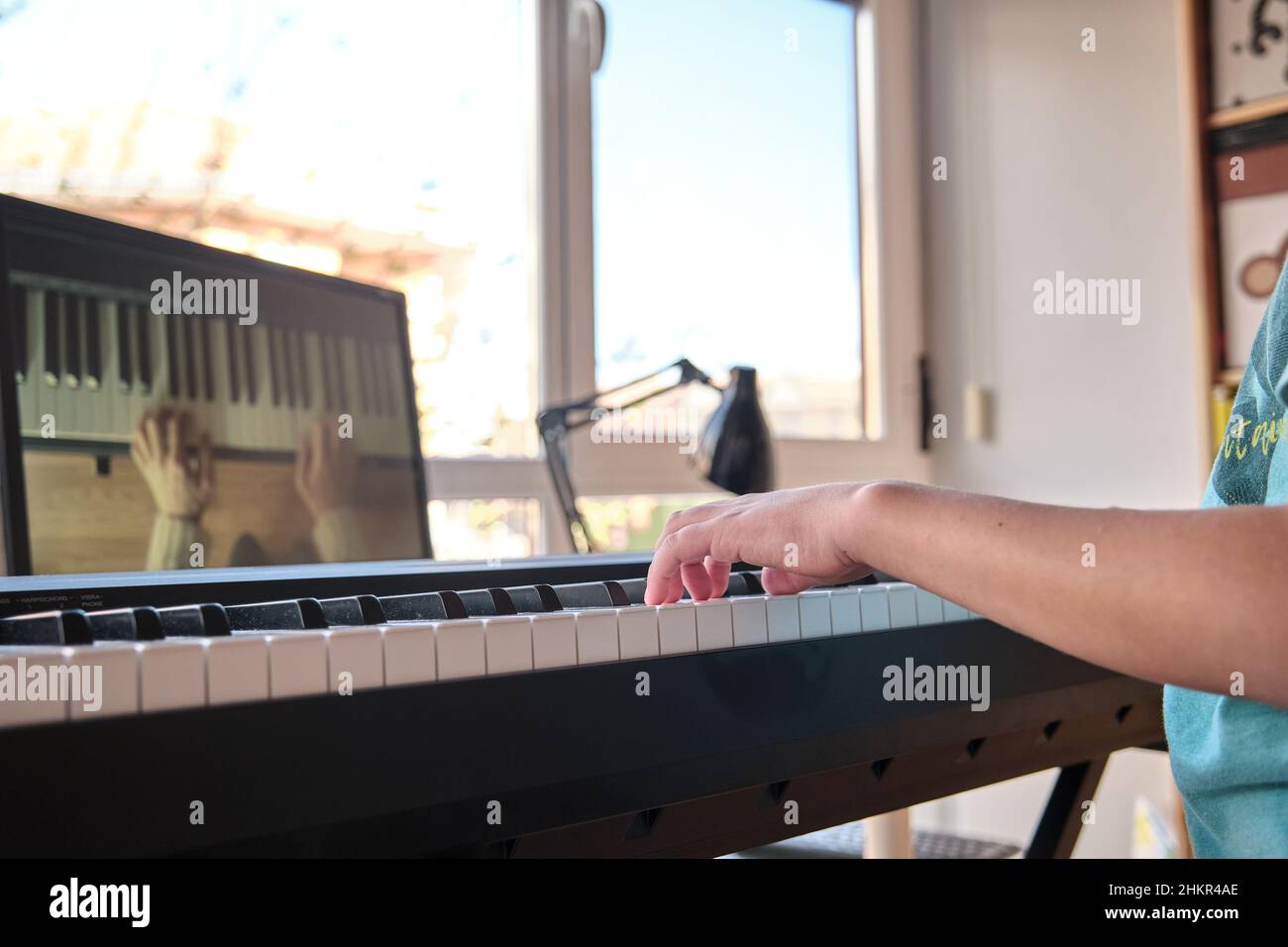 Teenager musicista che suona pianoforte digitale classico a casa durante la lezione online a casa, sociale distanza durante la quarantena, concetto di formazione online Foto Stock