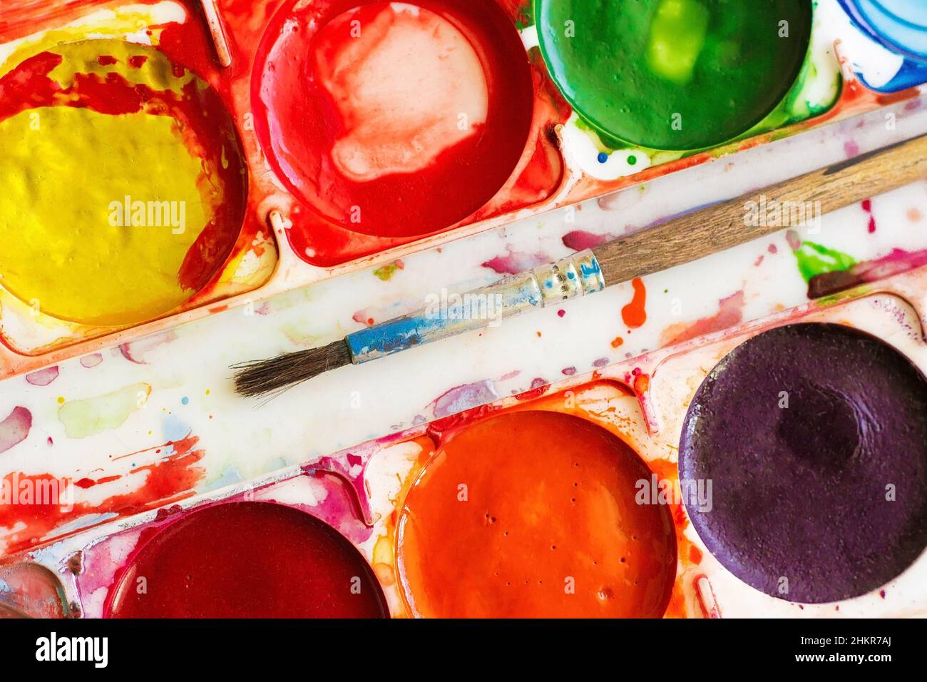 tavolozza vecchie vernici ad acqua colorate e pennello, isolato Foto Stock