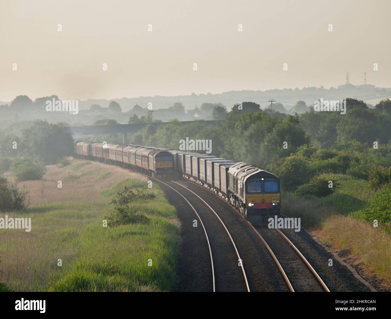 Direct Rail Services classe 66 locomotive che trasportano un treno container passando una locomotiva di classe 47 della West Coast Railroad sulla nebbia. Foto Stock