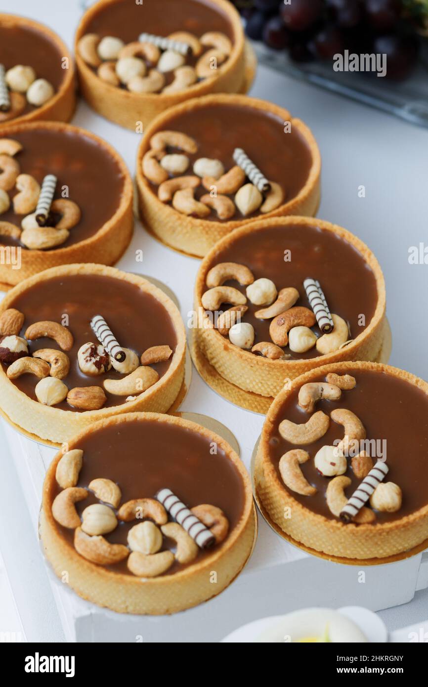 Torta deliziosa con nocciole, caramello dolce su tavola bianca. Foto Stock