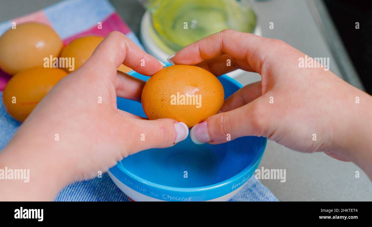 mani che mostrano un uovo di gallina per la ricetta Foto Stock