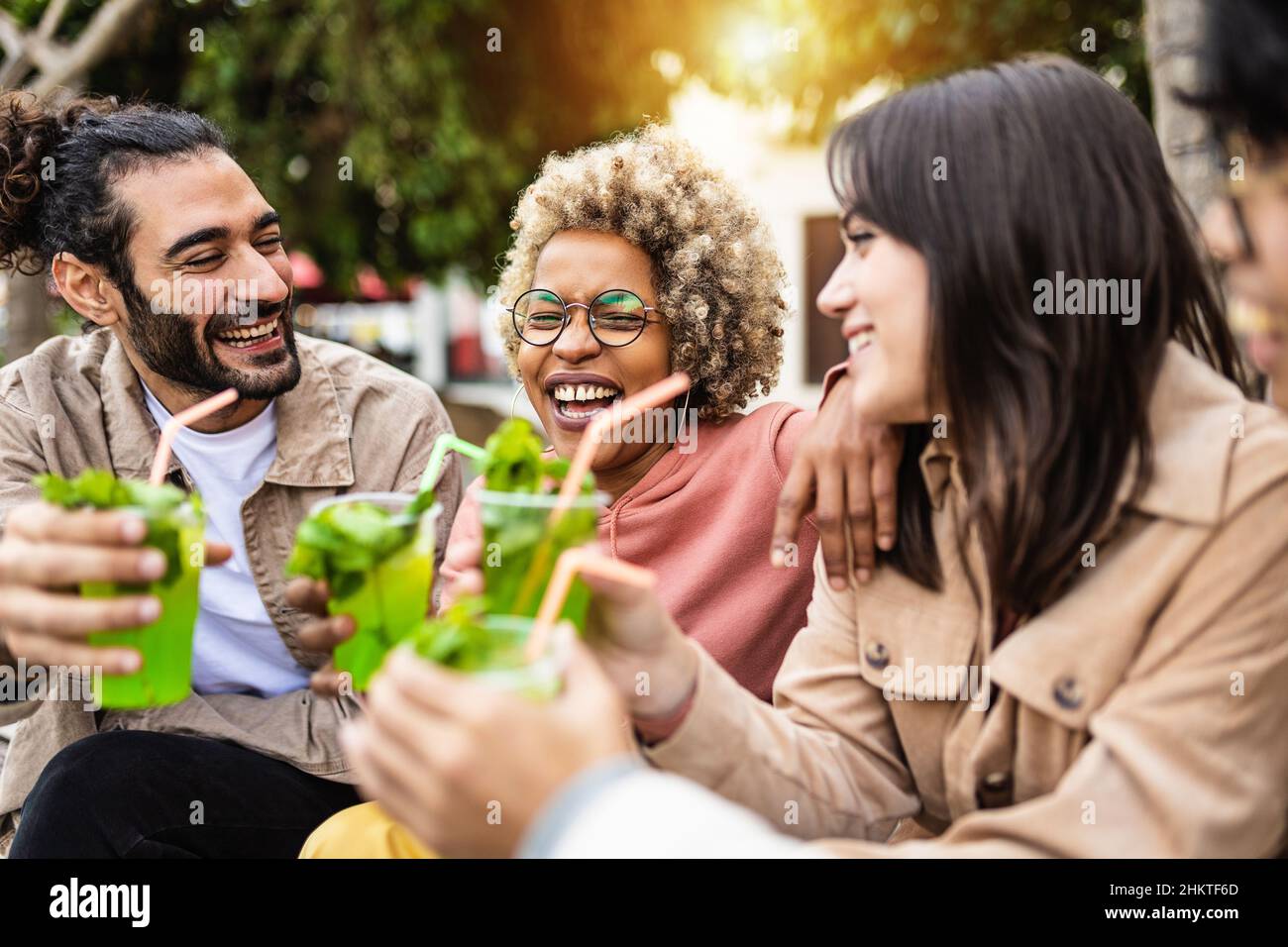 Amici turistici multirazziali ridere insieme e divertirsi a bere mojito Foto Stock