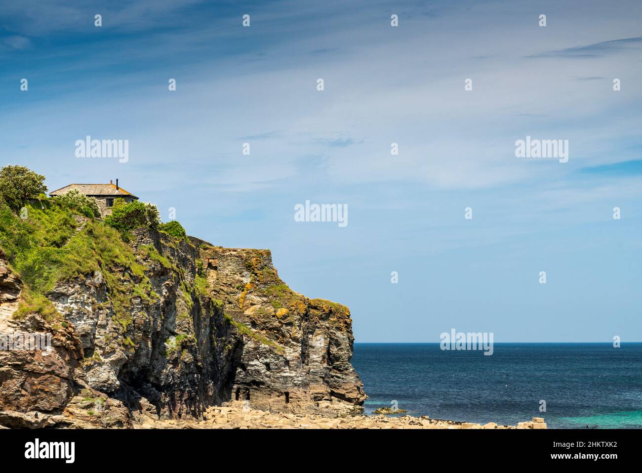 Tradizionale casa Cornovaglia vicino al bordo della scogliera nel punto spettacolare di bellezza della spiaggia di St Agnes sulla costa nord della Cornovaglia, un sole, caldo, metà giorno d'estate, o Foto Stock