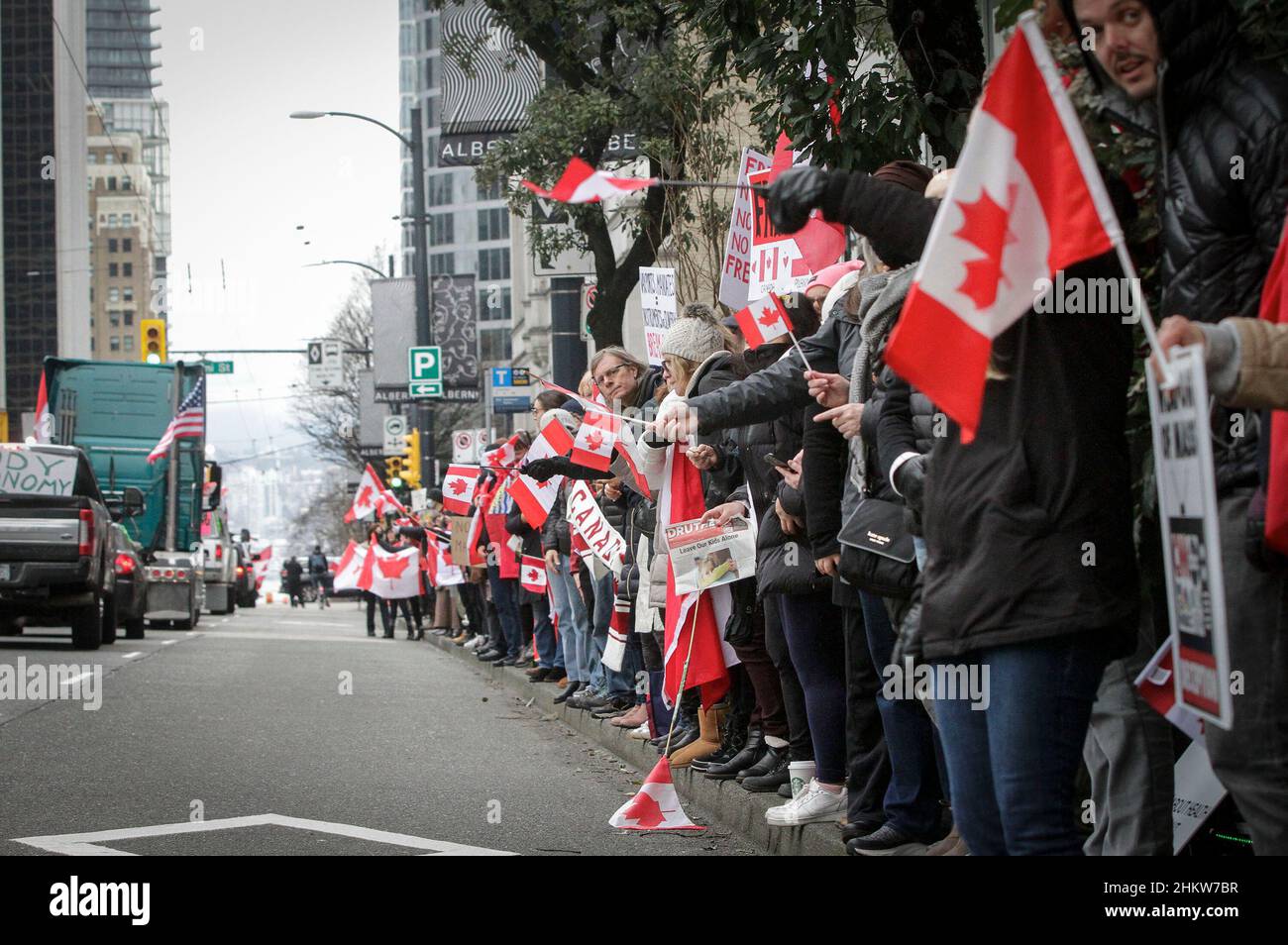 Vancouver, Canada. 5th Feb 2022. Le bandiere di onda della gente come veicoli partecipano ad un convoglio per sostenere i camionisti contro il mandato di vaccino COVID-19 nel centro di Vancouver, Canada, 5 febbraio 2022. In solidarietà con i manifestanti nel centro di Ottawa, i sostenitori del vaccino anti COVID-19 e le restrizioni a Vancouver hanno partecipato a convogli di veicoli e raduni protestando contro il mandato vaccinale del governo canadese per i lavoratori essenziali che attraversano il confine tra Canada e Stati Uniti. Credit: Liang Sen/Xinhua/Alamy Live News Foto Stock