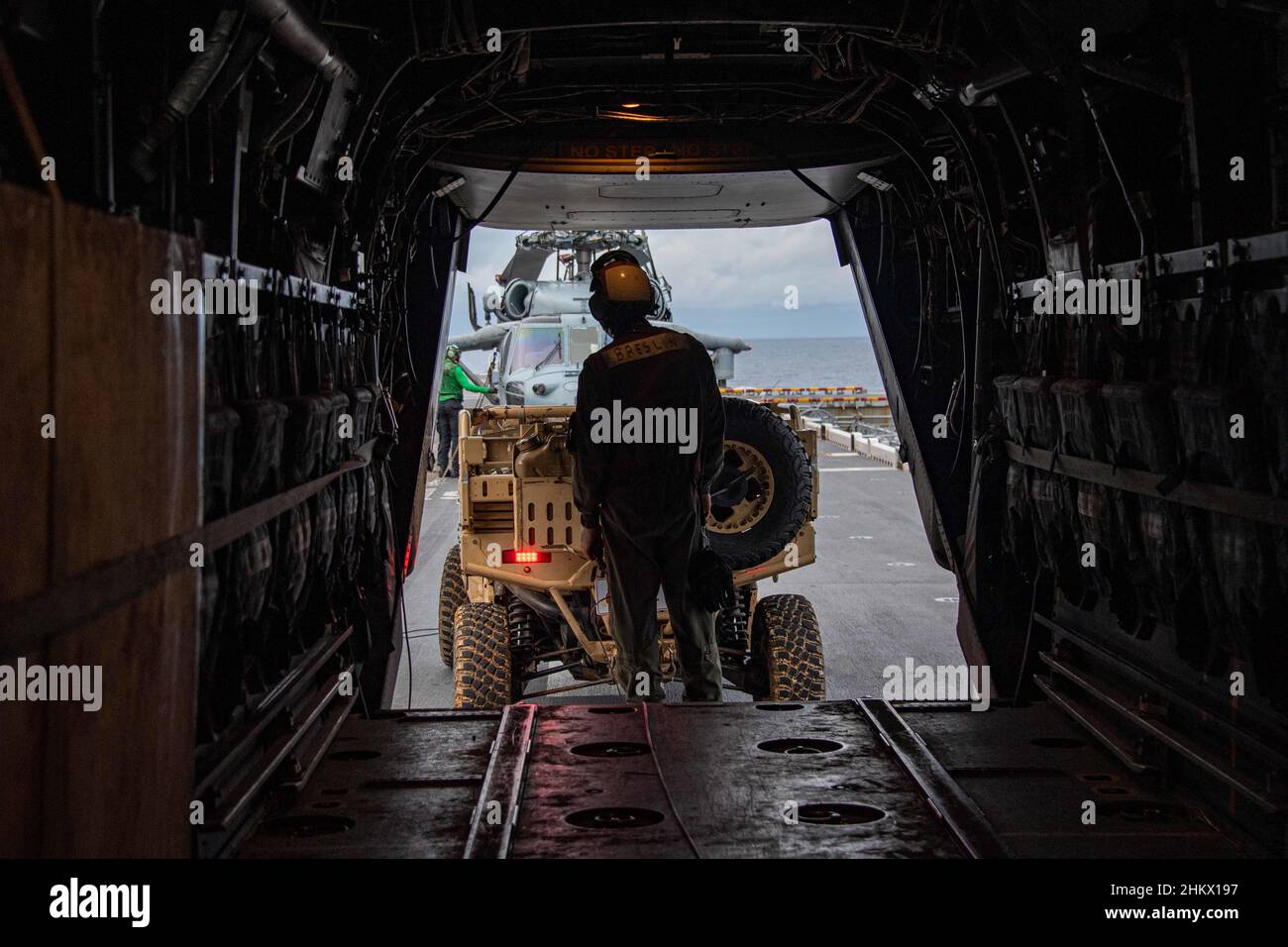 MAR DELLE FILIPPINE (Feb 4, 2022)il caporale Justin Breslin, della contea di Orange, California, assegnato alla 31st Marine Expeditionary Unit (MEU), carica un veicolo di servizio su un MV-22B Osprey tiltrotor aereo dal 31st MEU sul ponte di volo della nave d'assalto anfibio schierata in avanti USS America (LHA 6) durante l'esercizio congiunto Noble Fusion. Noble Fusion dimostra che le forze di spedizione navale stand-in schierate in avanti dalla Marina e dai corpi marini possono rapidamente aggregare le squadre Marine Expeditionary Unit/Amphibious Ready Group in mare, insieme a un gruppo di attacco portaerei, nonché ad altri gruppi di supporto Foto Stock