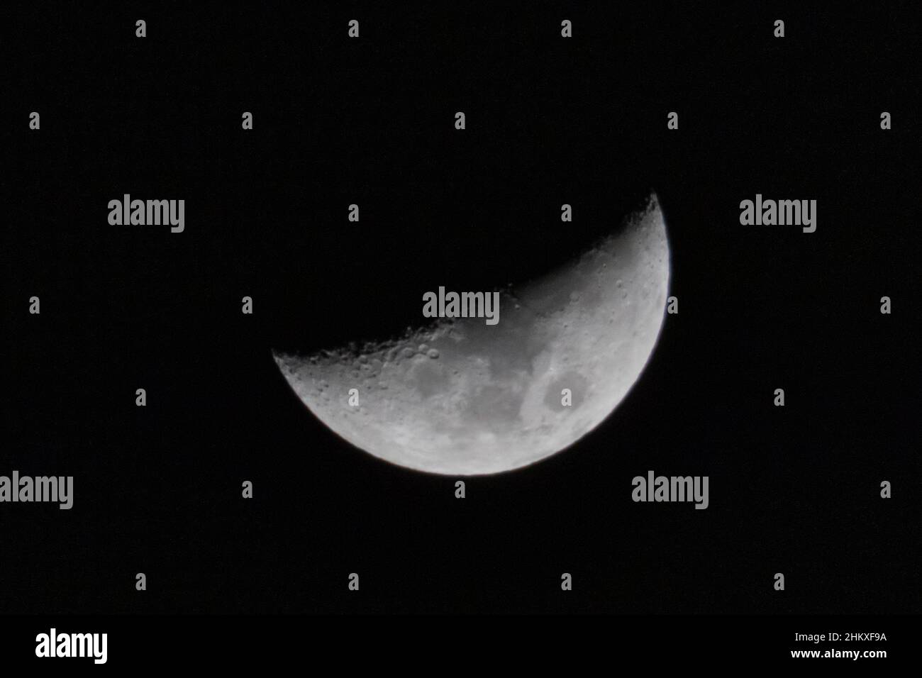 Primo piano foto della luna sul cielo blu. Foto realistica di mezza luna. Foto Stock