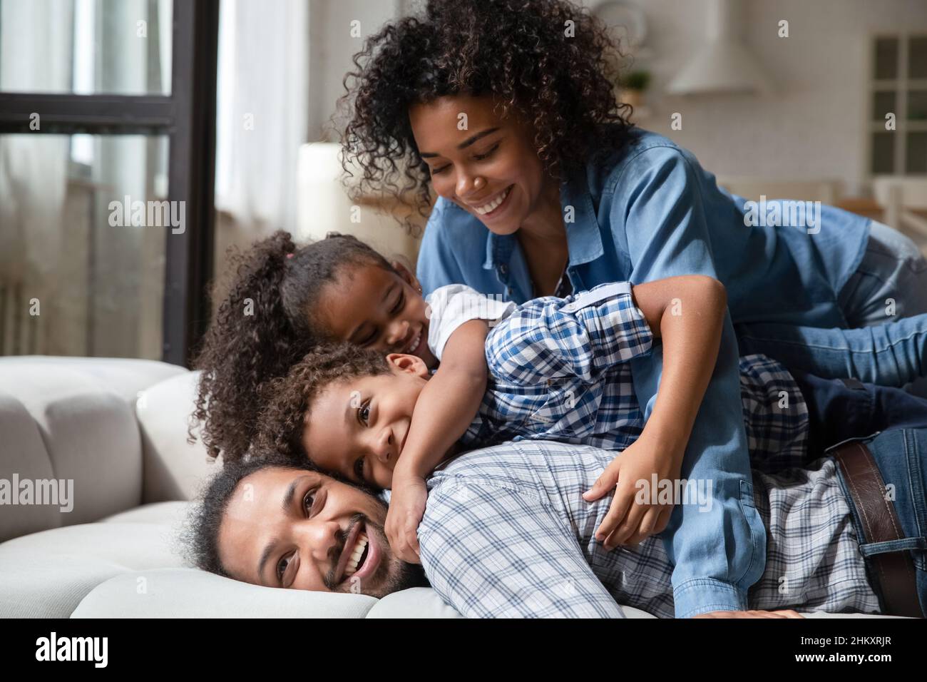 Sorridente famiglia afro-americana che passa un fine settimana spensierato a casa. Foto Stock
