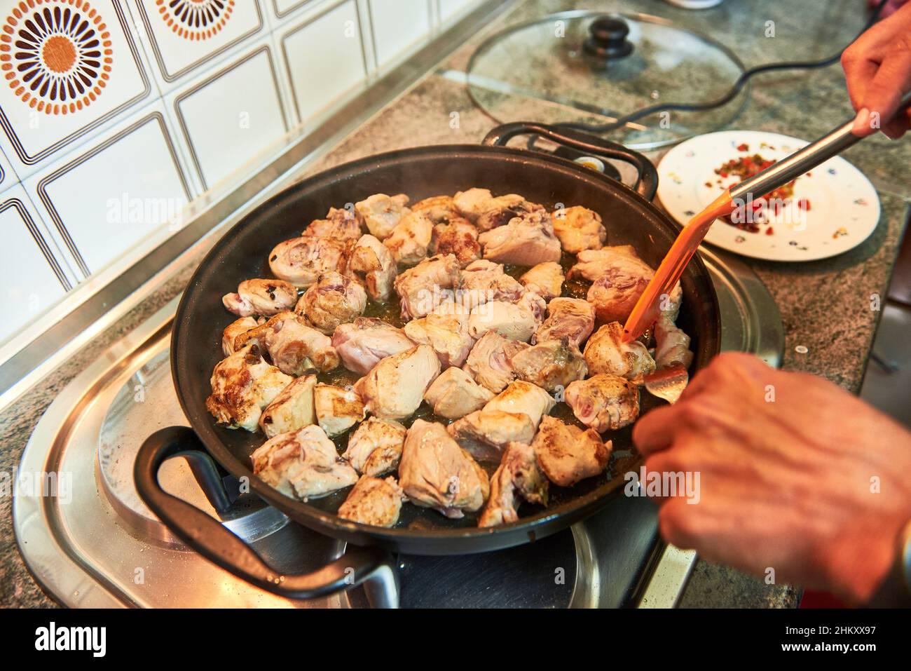 Preparazione del pollo all'aglio nella padella Foto Stock