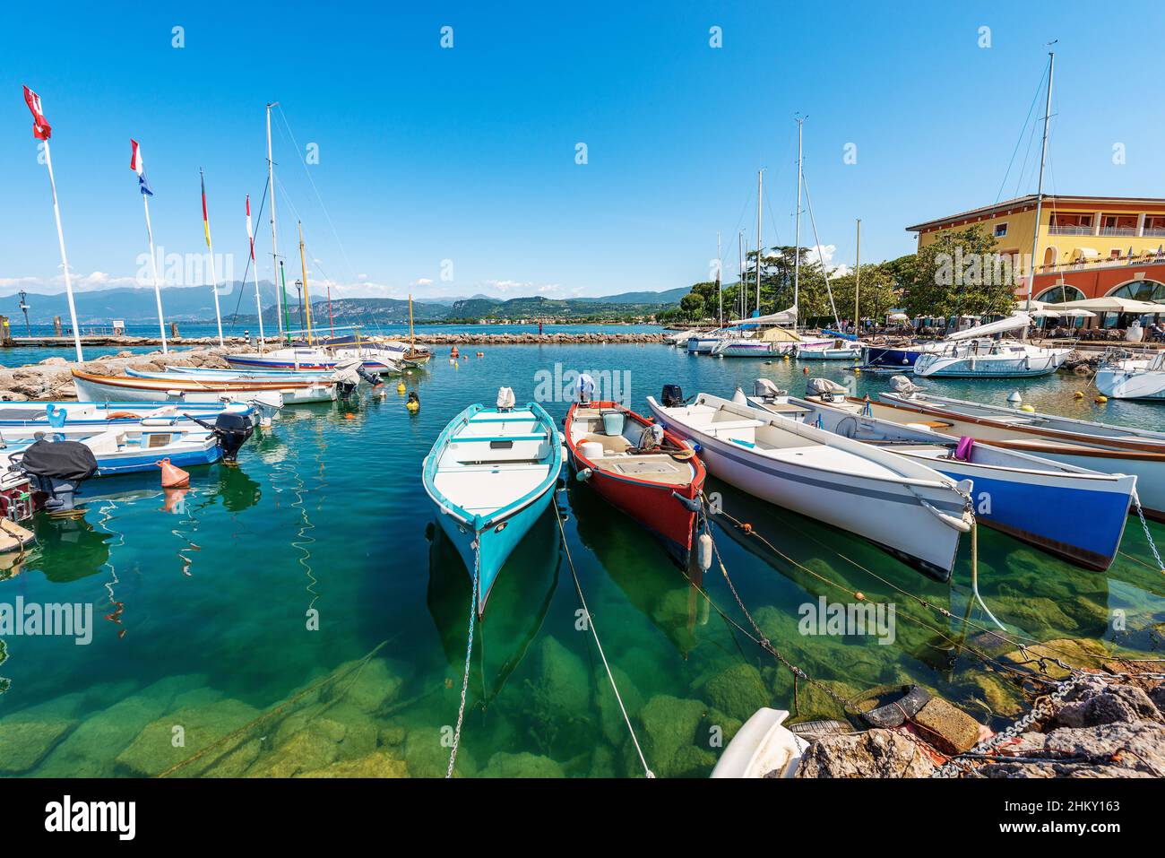 Piccolo porto del villaggio di Cisano con piccole barche ormeggiate. Località turistica sulla costa del Lago di Garda. Comune di Bardolino, Verona, Veneto, Italia. Foto Stock