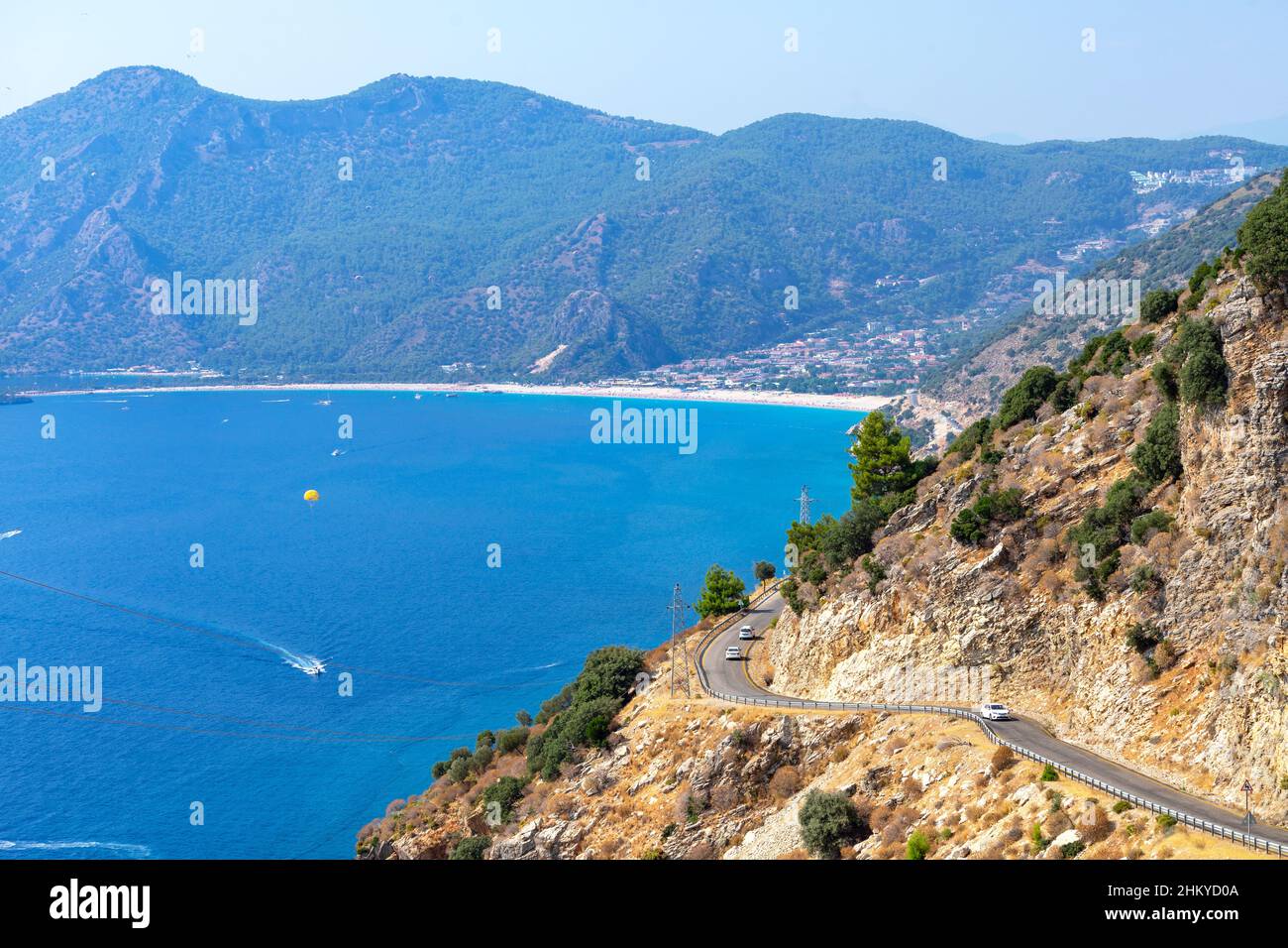 Curva curvilinea di strada di montagna con cielo blu e mare sullo sfondo. Fethiye Oludeniz spiaggia vista dalla collina, Turchia. Foto Stock