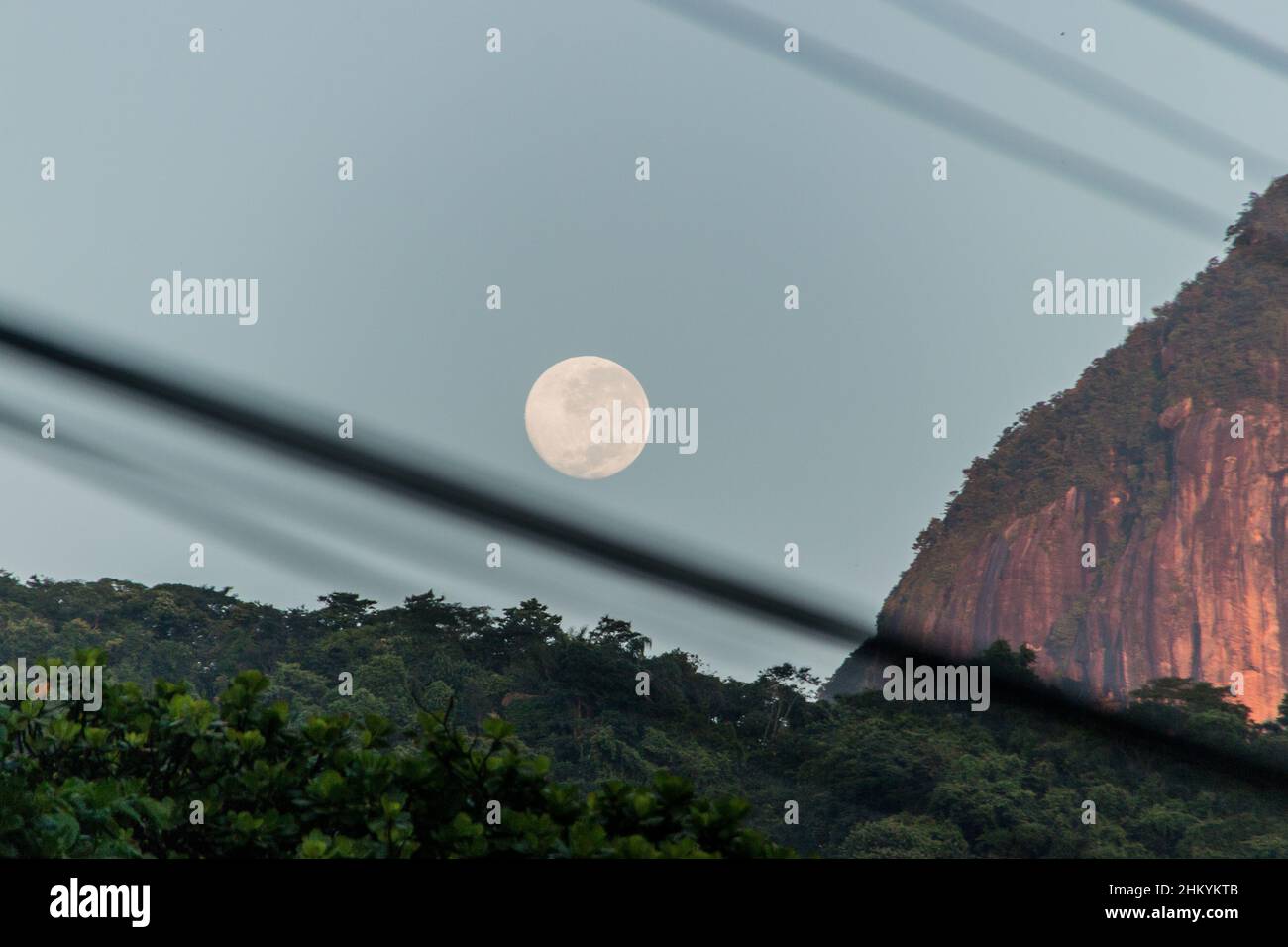 Moonset con silhouette di fili in Copacabana Rio de Janeiro, Brasile. Foto Stock