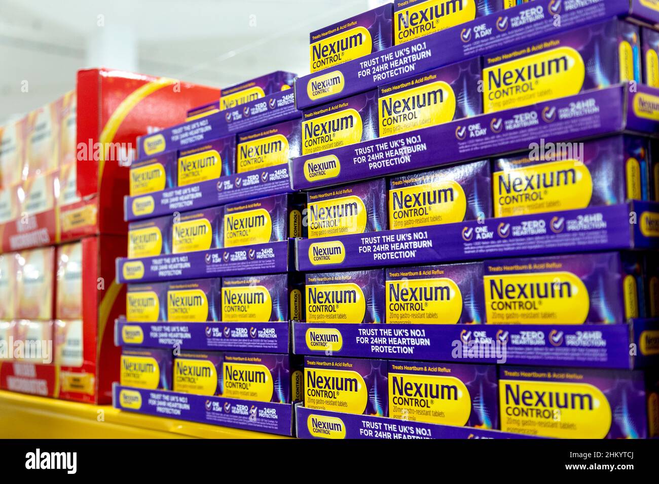 Scatole di Nexium sopra il contatore bruciore di stomaco e farmaco di riflusso acido su una mensola del supermercato Foto Stock