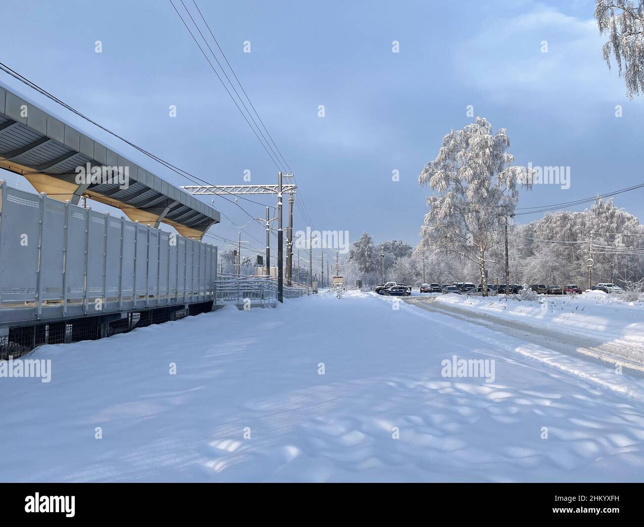 Piattaforma ferroviaria vuota senza passeggeri in inverno al tramonto. Ferrovia, concetto di clima freddo, fuoco selettivo e softfocus Foto Stock