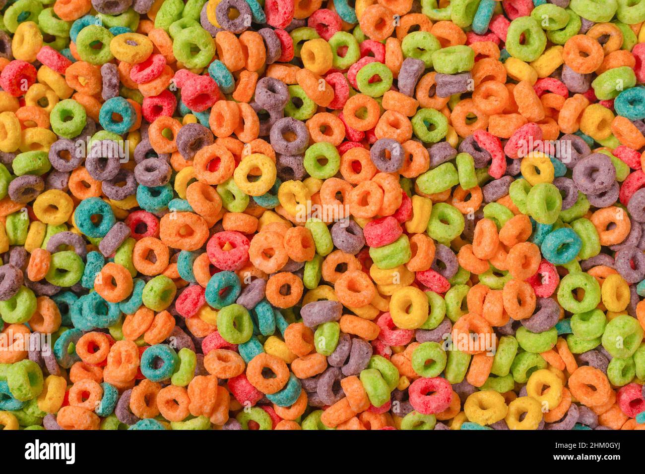 Dolci fiocchi multicolore, anelli di cereali come sfondo. Foto Stock