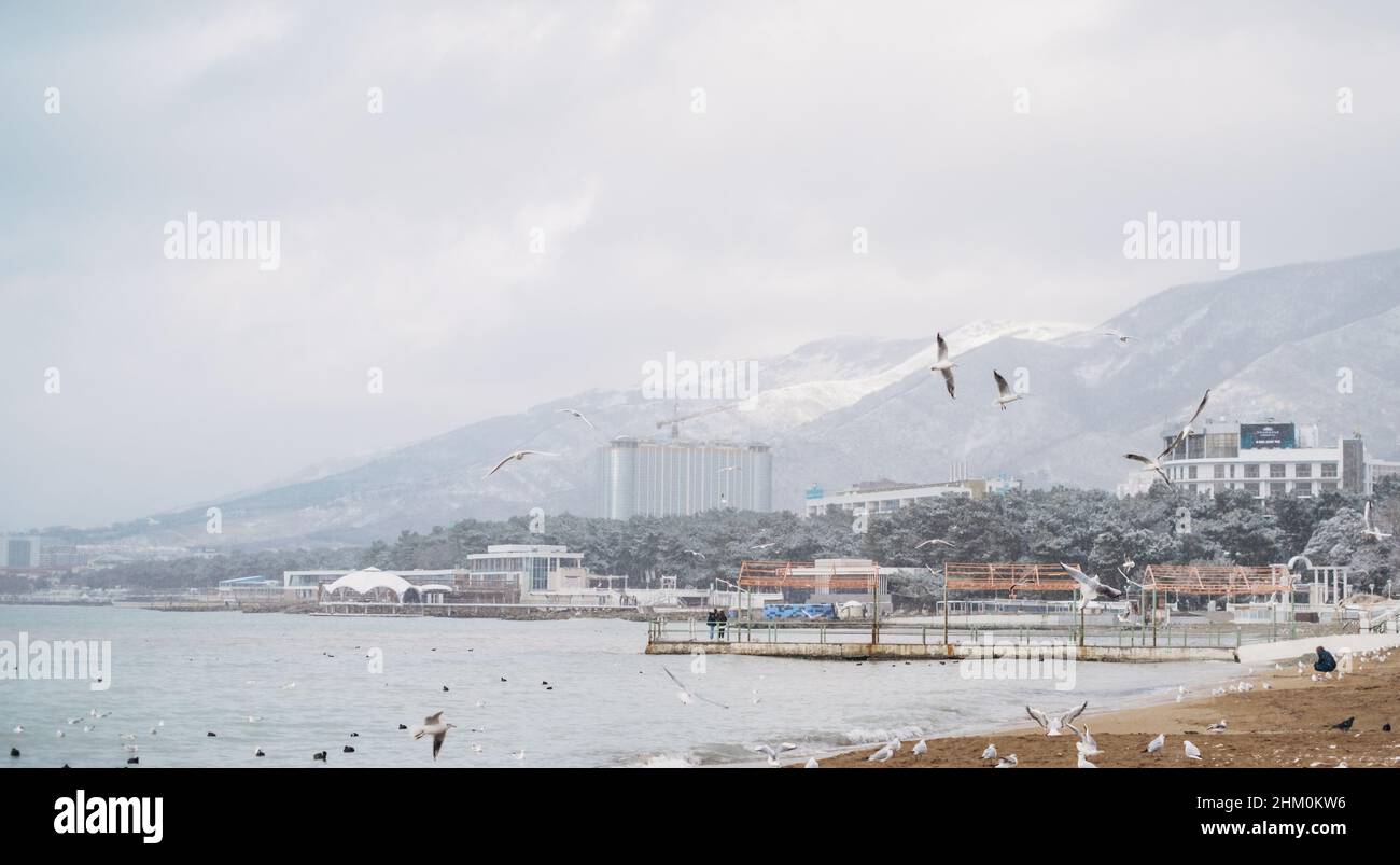Spiaggia della città durante la stagione invernale, con il Markotkh Range sullo sfondo. Foto Stock