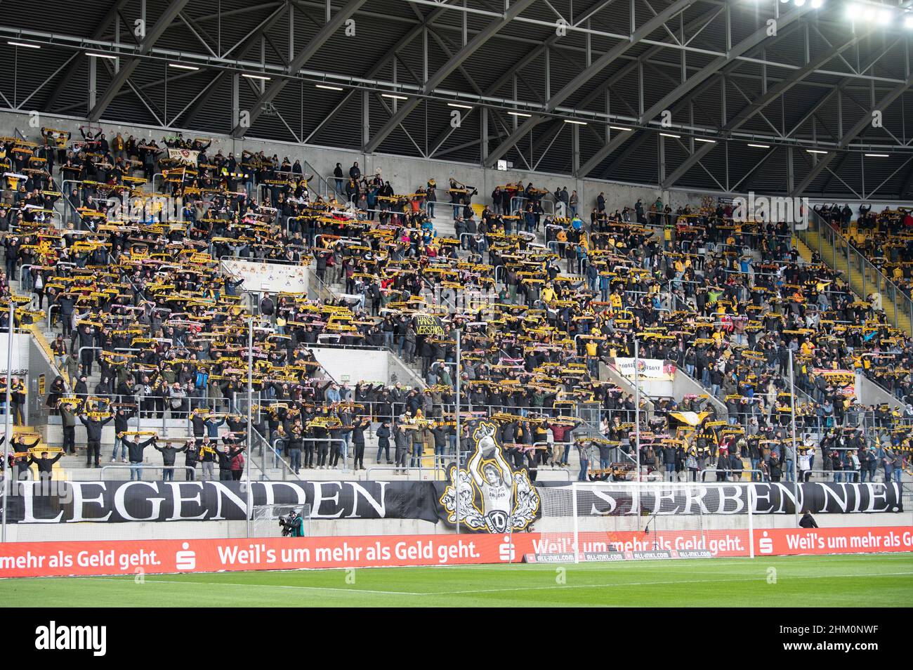 06 Febbraio 2022, Sassonia, Dresda: Calcio: 2nd Bundesliga, Dynamo Dresden - Hansa Rostock, Matchday 21 a Rudolf-Harbig-Stadion: I fan di Drino Dresden stanno dietro una bandiera che legge 'Legends Never die' negli stand prima del gioco. Foto: Sebastian Kahnert/dpa-Zentralbild/dpa - NOTA IMPORTANTE: In conformità con i requisiti del DFL Deutsche Fußball Liga e del DFB Deutscher Fußball-Bund, è vietato utilizzare o utilizzare fotografie scattate nello stadio e/o del match sotto forma di sequenze fotografiche e/o di serie video-simili. Foto Stock