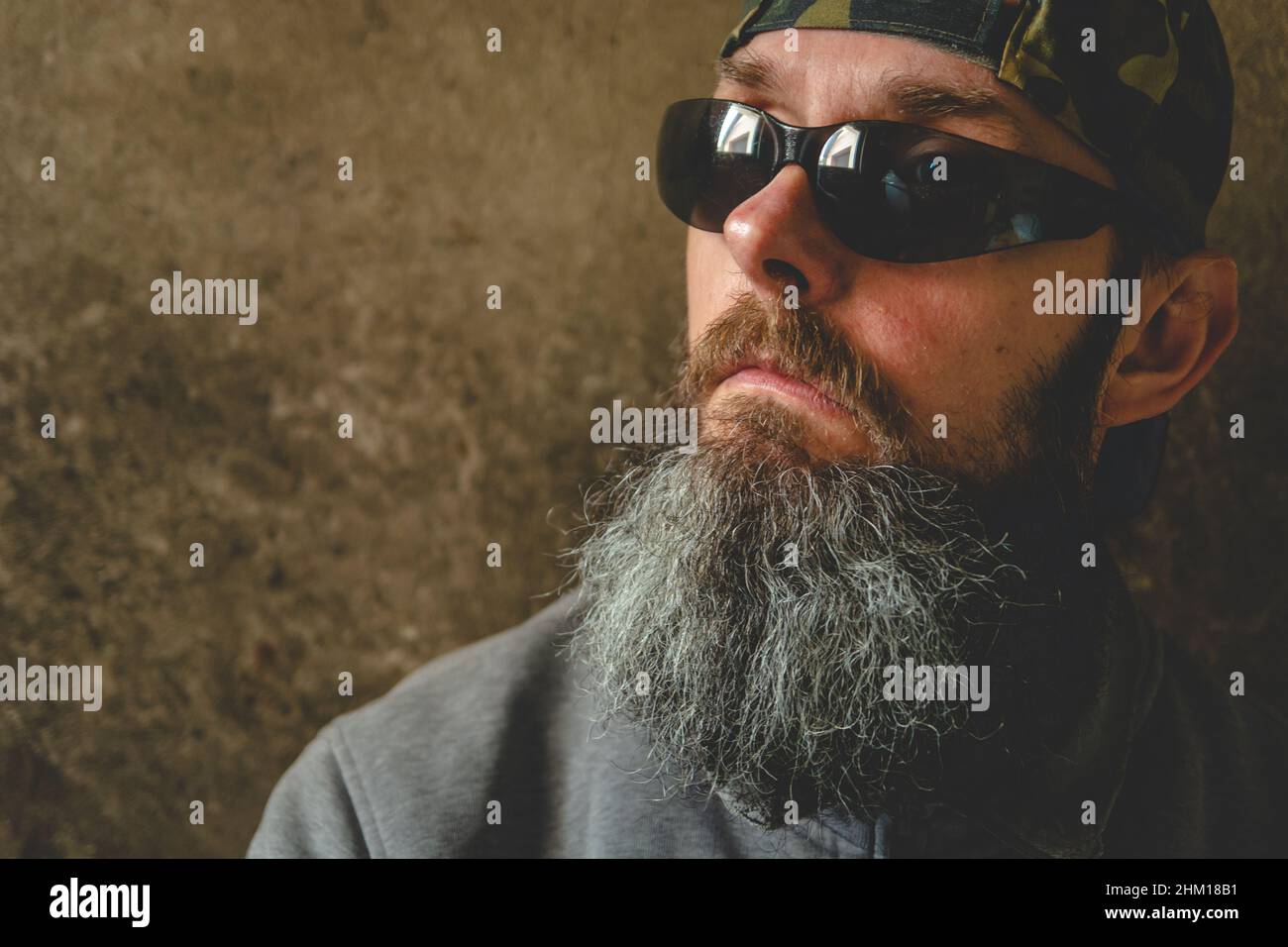 Un uomo con una barba lunga che indossa occhiali da sole, ritratto Foto Stock