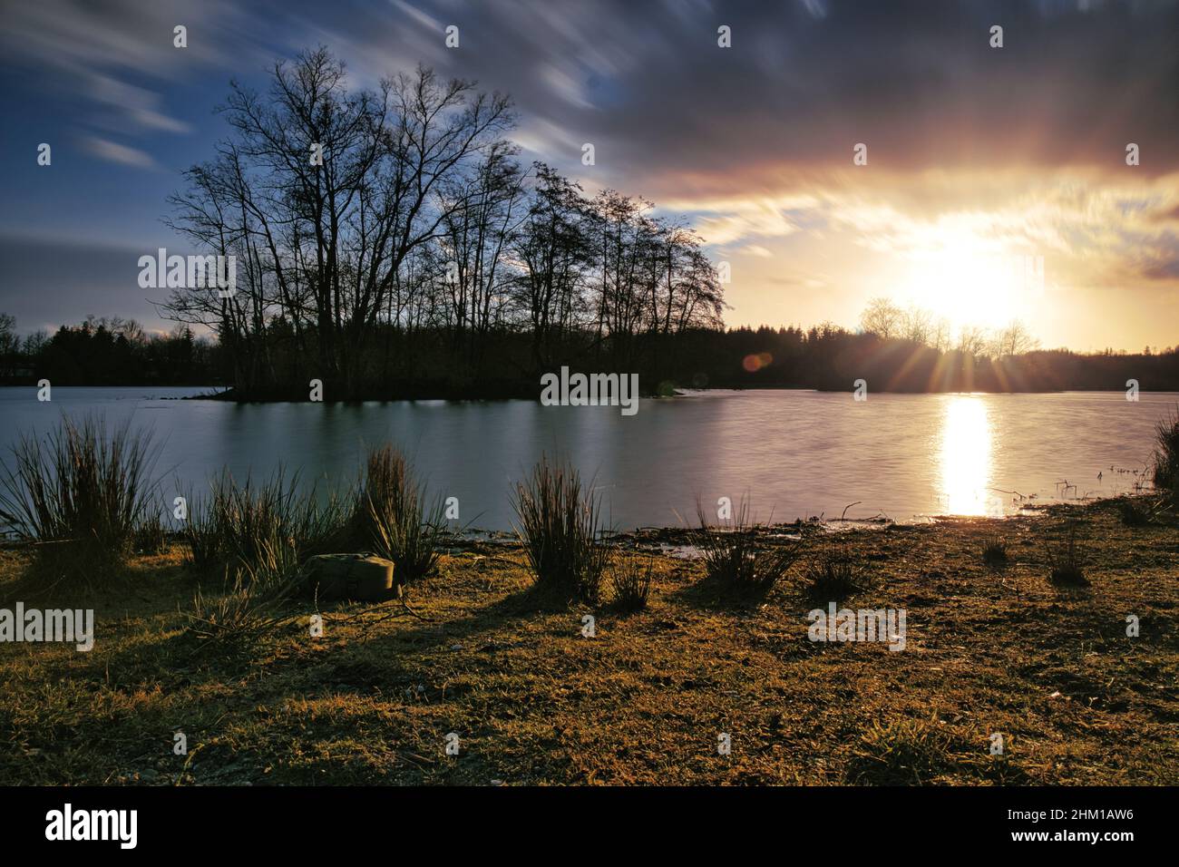 Tramonto su un piccolo lago con un'isola Foto Stock