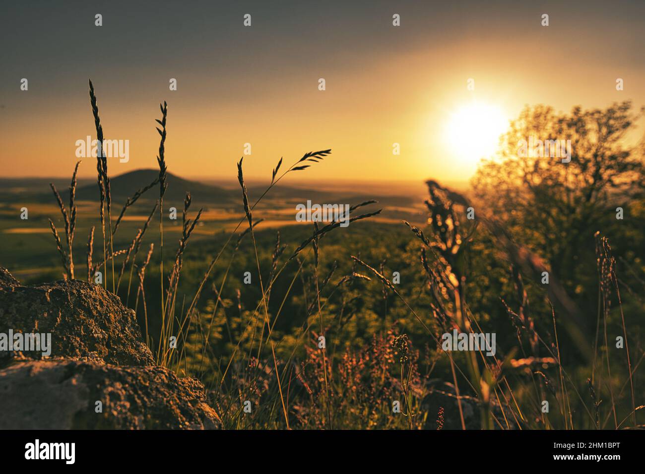 splendido tramonto su una collina con una vista idilliaca in lontananza Foto Stock