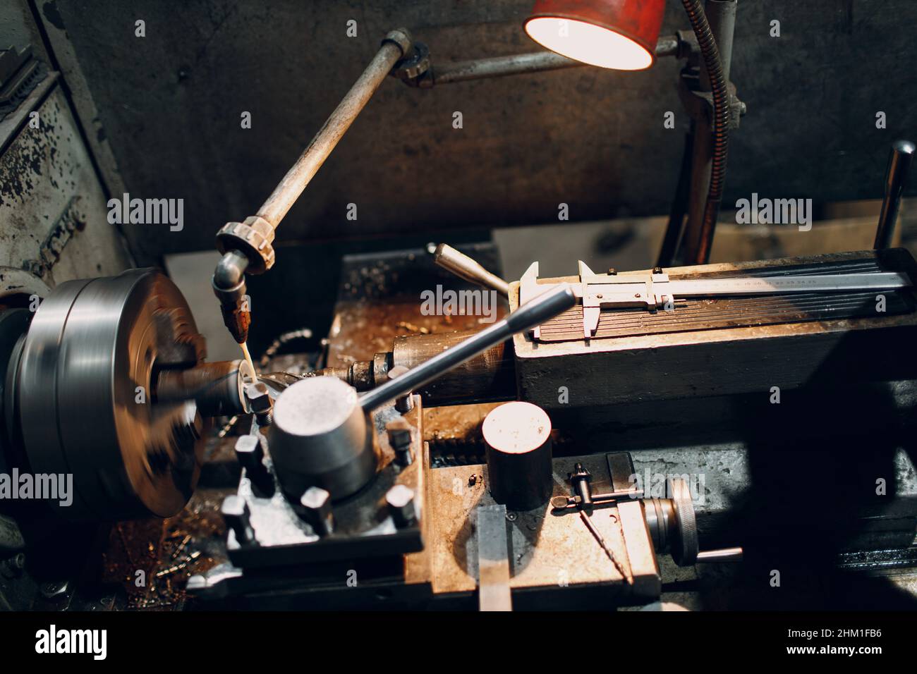 Lavoratore Turner che lavora in fabbrica su una vecchia macchina da tornio Foto Stock