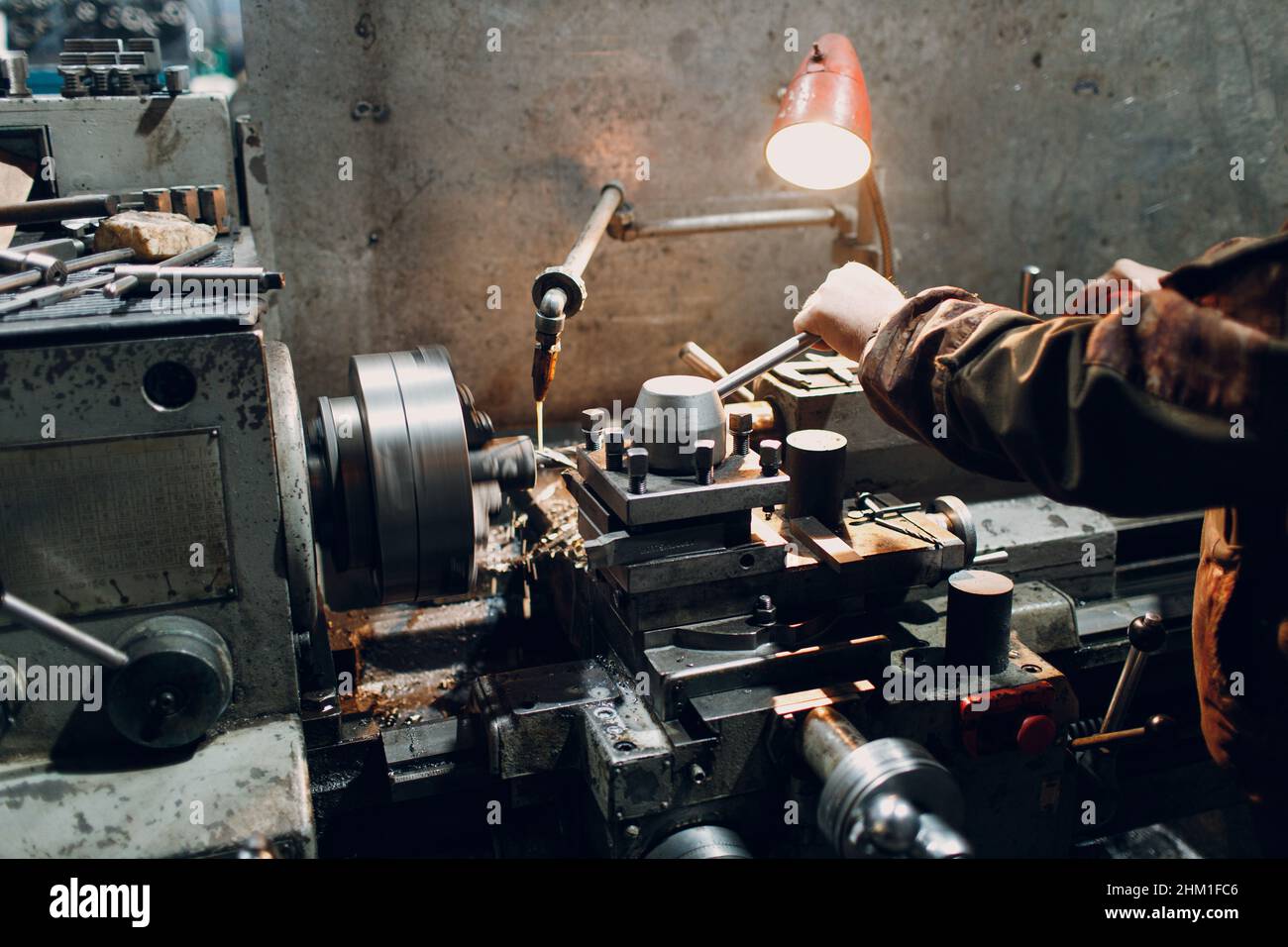 Lavoratore Turner che lavora in fabbrica su una vecchia macchina da tornio Foto Stock