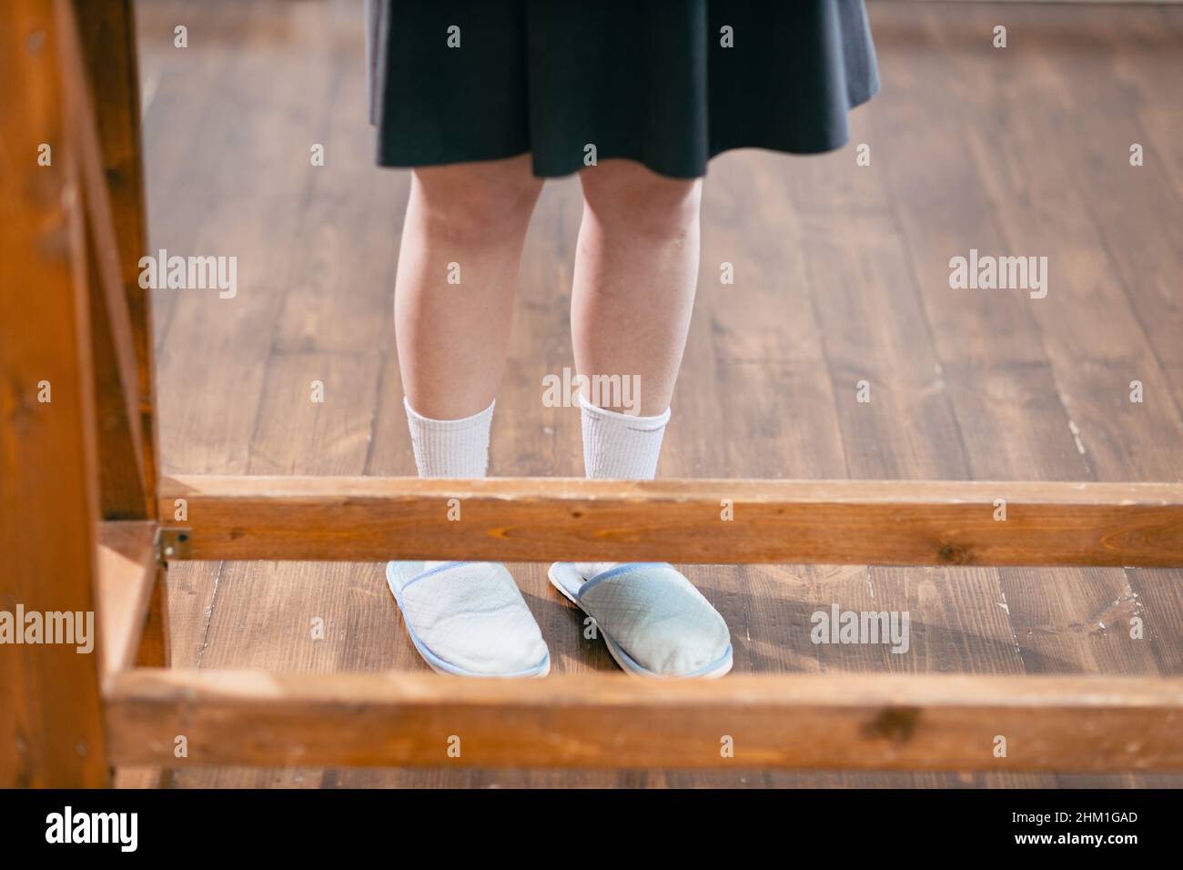 Donna gambe con abito grigio primo piano calzini pantofole in cucina Foto Stock