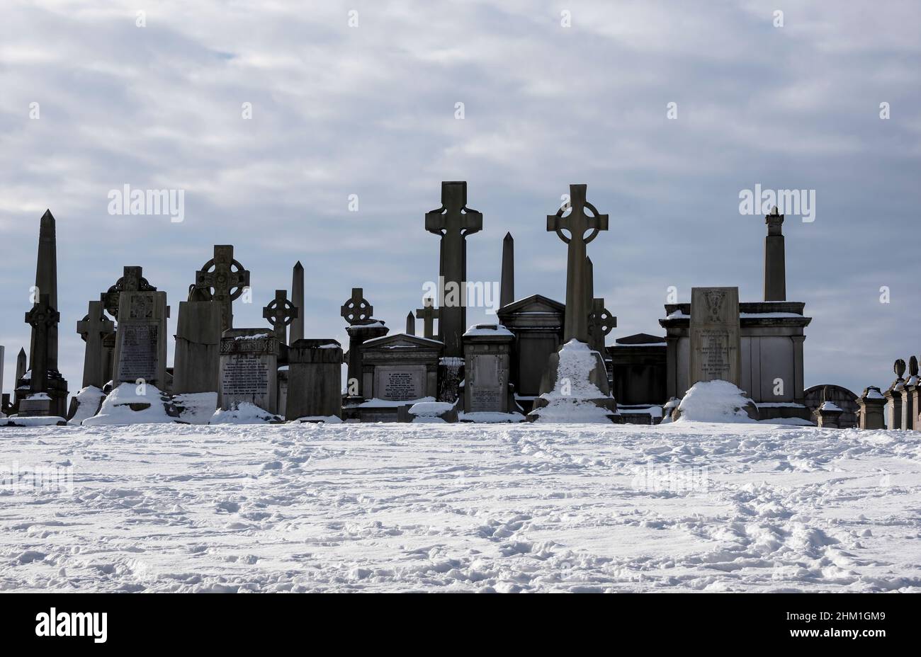Lapidi nella neve al cimitero di Necropoli, Glasgow, Scozia. Foto Stock