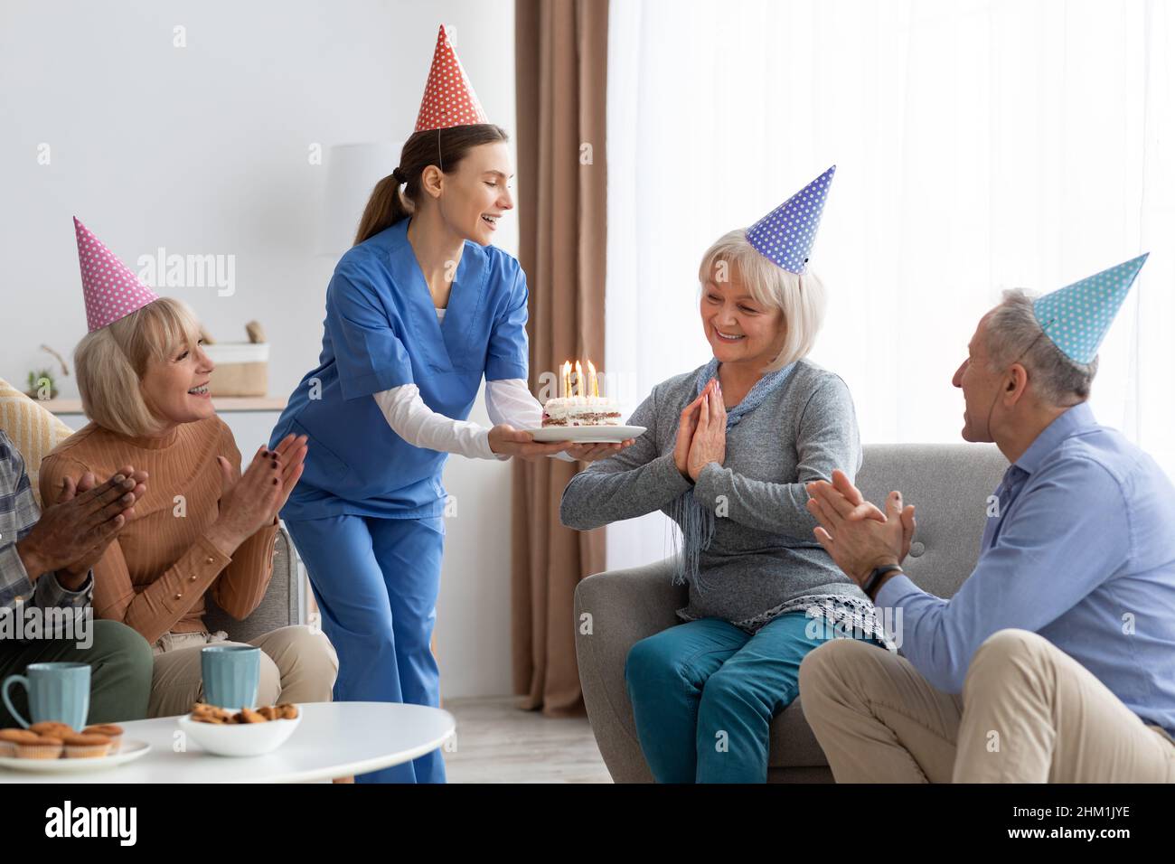 Festa di compleanno a casa di cura, anziani che festeggia il compleanno Foto Stock