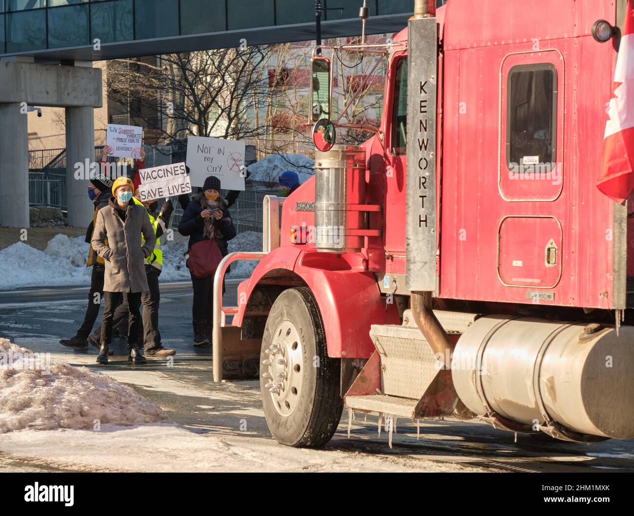 Halifax, Nuova Scozia, Canada. Febbraio 6th, 2022. Locali che bloccano il percorso del convoglio della libertà per mostrare il loro dispiacere con la loro presenza per strada all'inizio del rally. Il Freedom Convoy 2022 contro tutti i mandati di Covid-19 colpisce le strade di Halifax, con centinaia di auto, pick-up camion e alcuni camion che attraversano le strade. Foto Stock