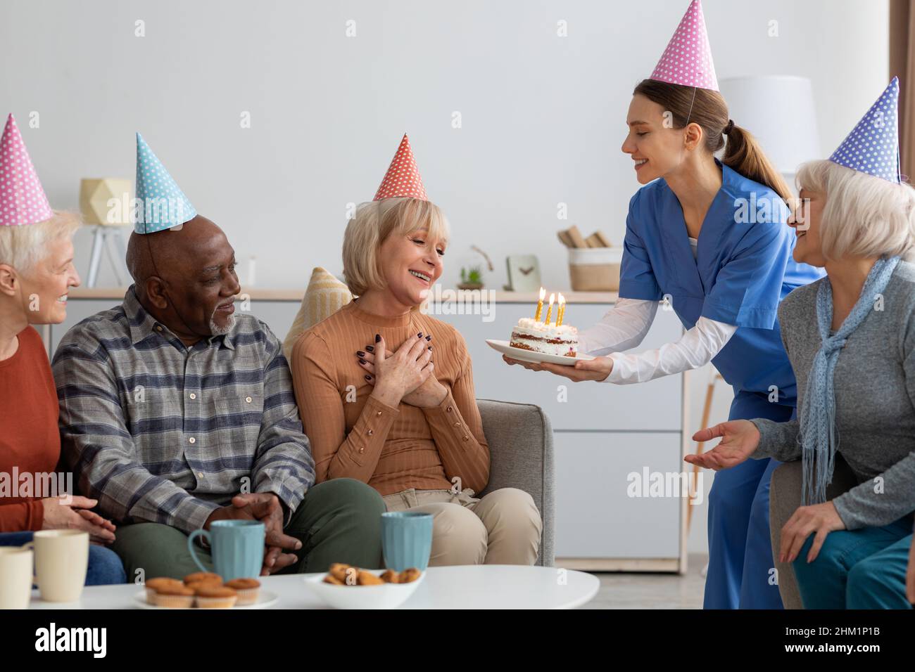Donna anziana che ha festa di compleanno a casa di cura Foto Stock
