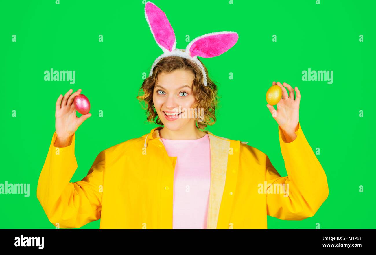 Buon giorno di Pasqua. Donna sorridente in orecchie conigliate con uova colorate. Caccia alle uova. Coniglio ragazza. Foto Stock