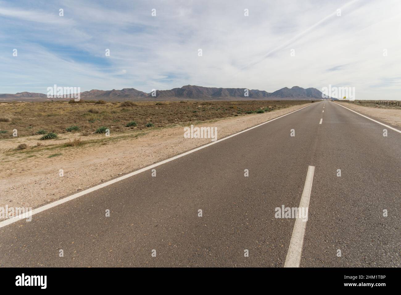 Strada senza fine, verso le montagne di Cabo de Gata, Almeria, Spagna. Foto Stock