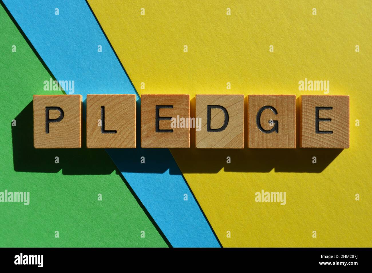 Pegno, parola in lettere di legno alfabeto isolato su sfondo colorato Foto Stock
