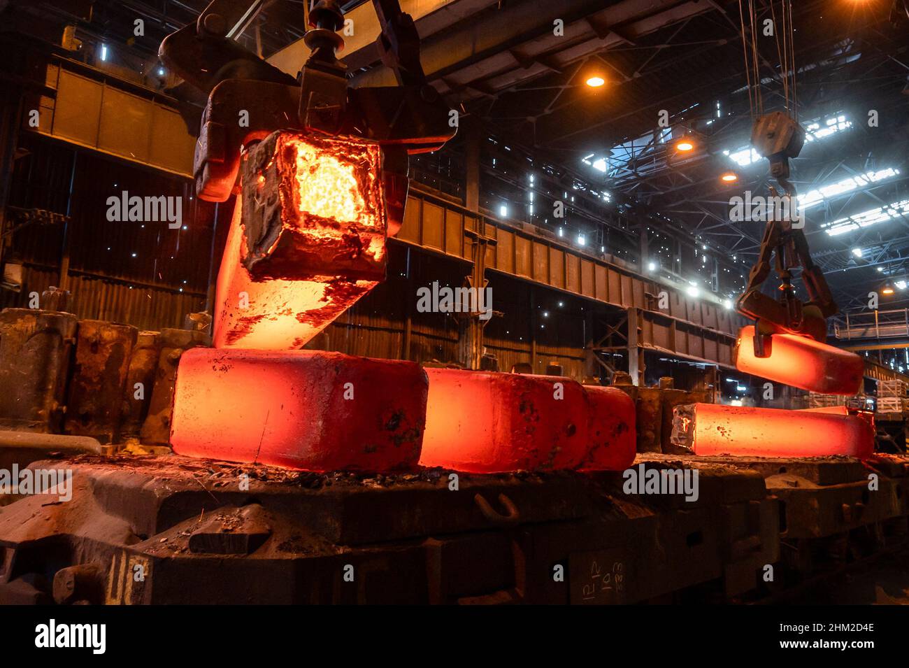 La fusione di metallo rosso-caldo è impilata sulla piattaforma Foto Stock