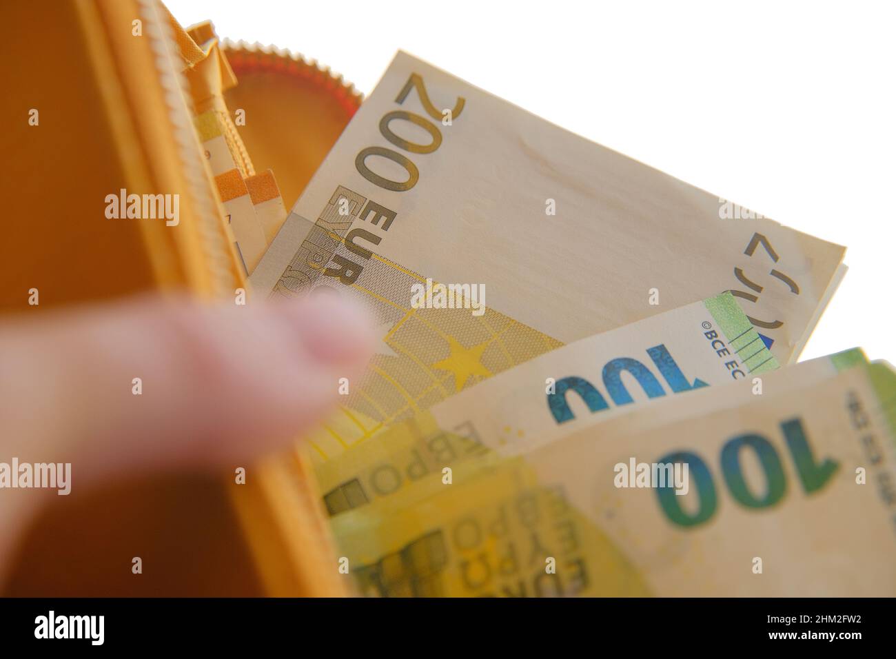 Portafoglio con valuta Money.Euro. Euro fattura in una borsa gialla in mani femminili su uno sfondo. Foto Stock