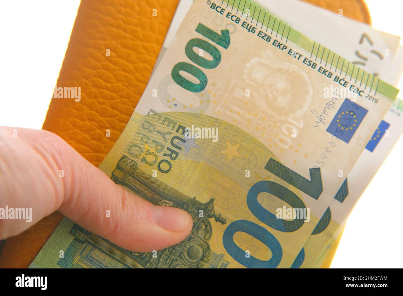 Portafoglio con valuta Money.Euro. Euro fattura in una borsa gialla in mani femminili su uno sfondo. Moneta dell'Unione europea. Foto Stock