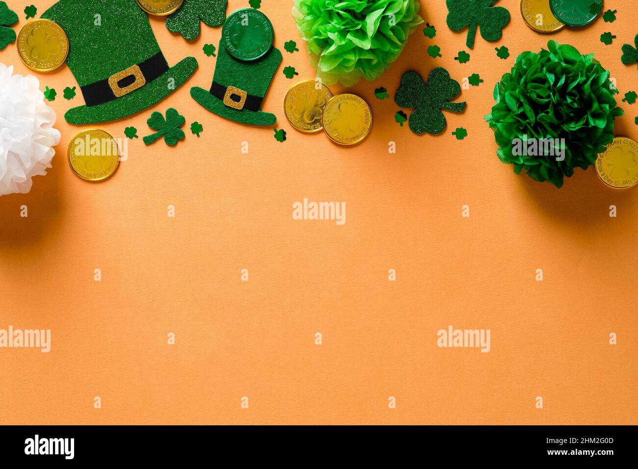 Sfondo del giorno di San Patrizio con cappelli di leprechauns, foglie di trifoglio shamrock, monete d'oro e decorazioni verdi. Disposizione piatta, vista dall'alto, spazio di copia. Buon San Pat Foto Stock