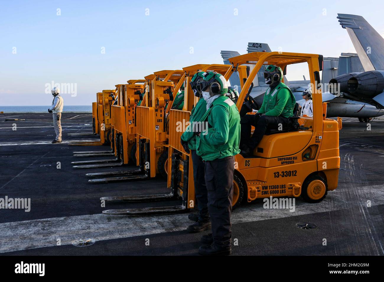 MAR DELLE FILIPPINE (Feb 4, 2022) i marinai del dipartimento di fornitura si trovano sul ponte di volo del vettore aereo di classe Nimitz USS Abraham Lincoln (CVN 72) per ricevere il carico dalla nave militare Sealift Command dry cargo e munizioni USNS Matthew Perry (T-AKE 9) durante un rifornimento in mare. Abraham Lincoln Strike Group è in fase di implementazione pianificata nell'area delle operazioni della flotta USA 7th per migliorare l'interoperabilità attraverso alleanze e partnership, fungendo da forza di risposta pronta a supportare una regione indopacifica libera e aperta. (STATI UNITI Foto Navy di Mass Communication Specialist 3 Foto Stock