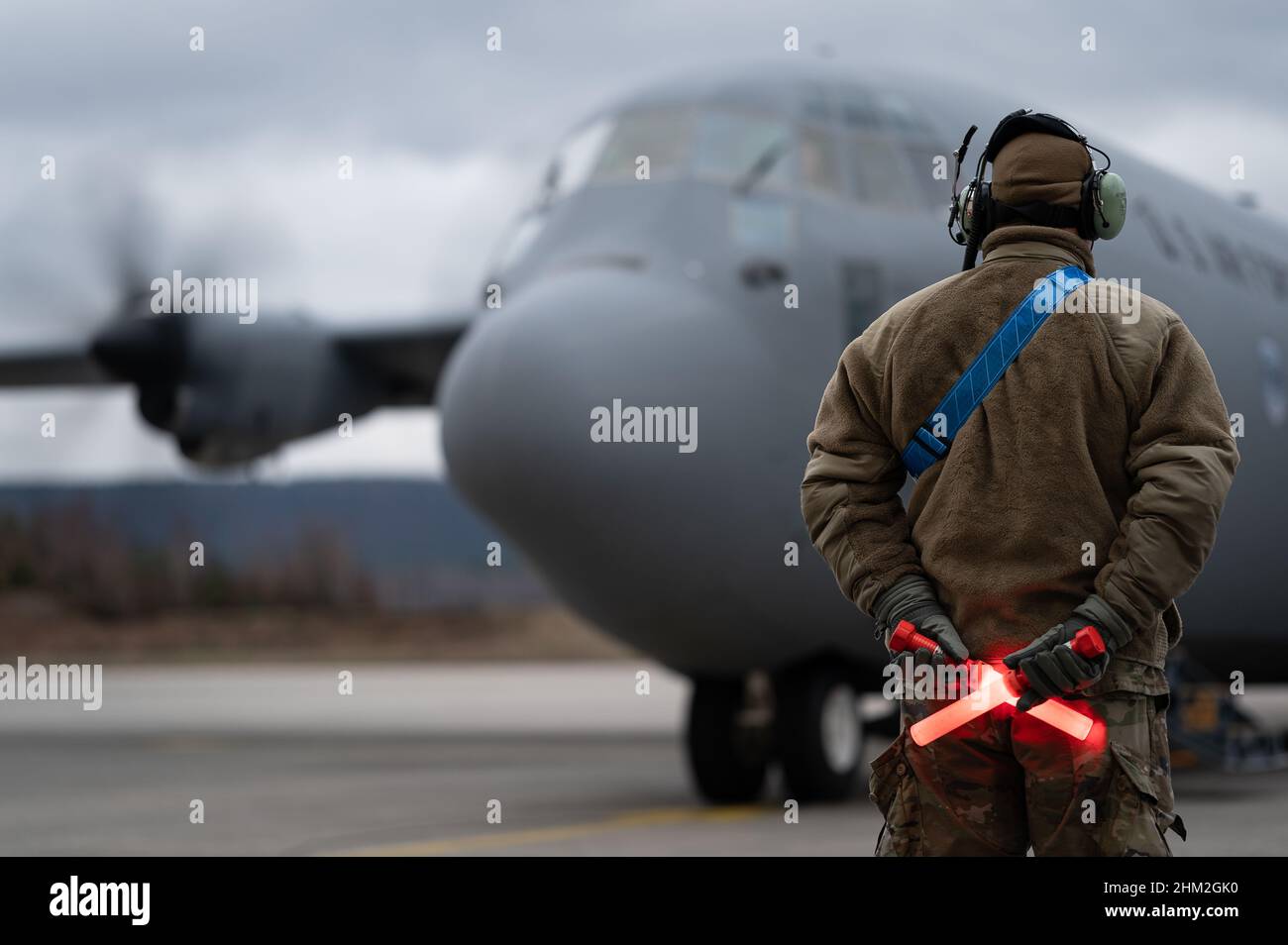 Un Airman dell'aeronautica degli Stati Uniti assegnato alla base aerea di Ramstein, Germania, marshalls un velivolo C-130J del Super Hercules prima della partenza, 3 febbraio 2022. Un piccolo elemento di 435th personale del gruppo di risposta alle emergenze si è dispiegato in Polonia, su richiesta del governo, per prepararsi ad assistere gli sforzi umanitari derivanti da una possibile incursione russa in Ucraina. (STATI UNITI Air Force foto di Airman Edgar 1st Classe Grimaldo) Foto Stock