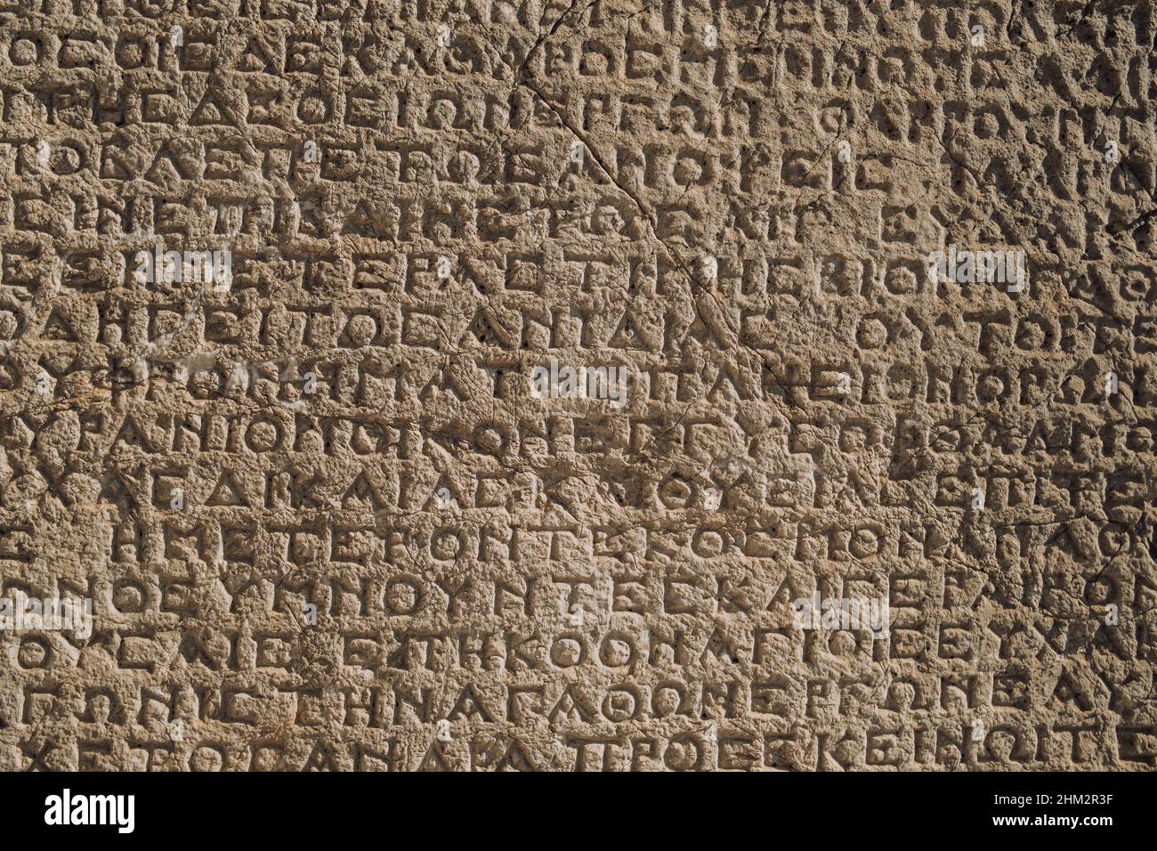 Antiche iscrizioni greche sul muro di rovine archeologiche da vicino Foto Stock