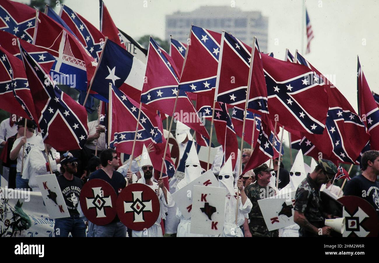 Houston Texas USA, 1990: Membri del gruppo supremacista bianco Ku Klux Klan marzo centro portando bandiere confederate. ©Bob Daemmrich Foto Stock